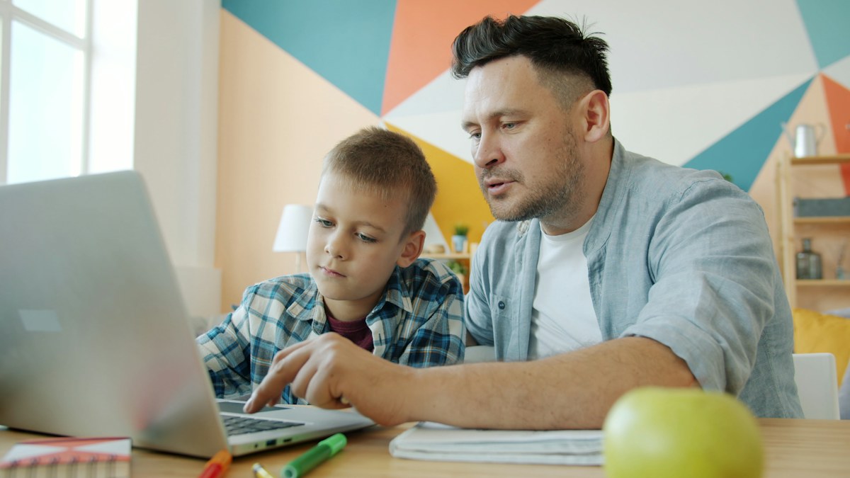 Father and young child learning together at home.