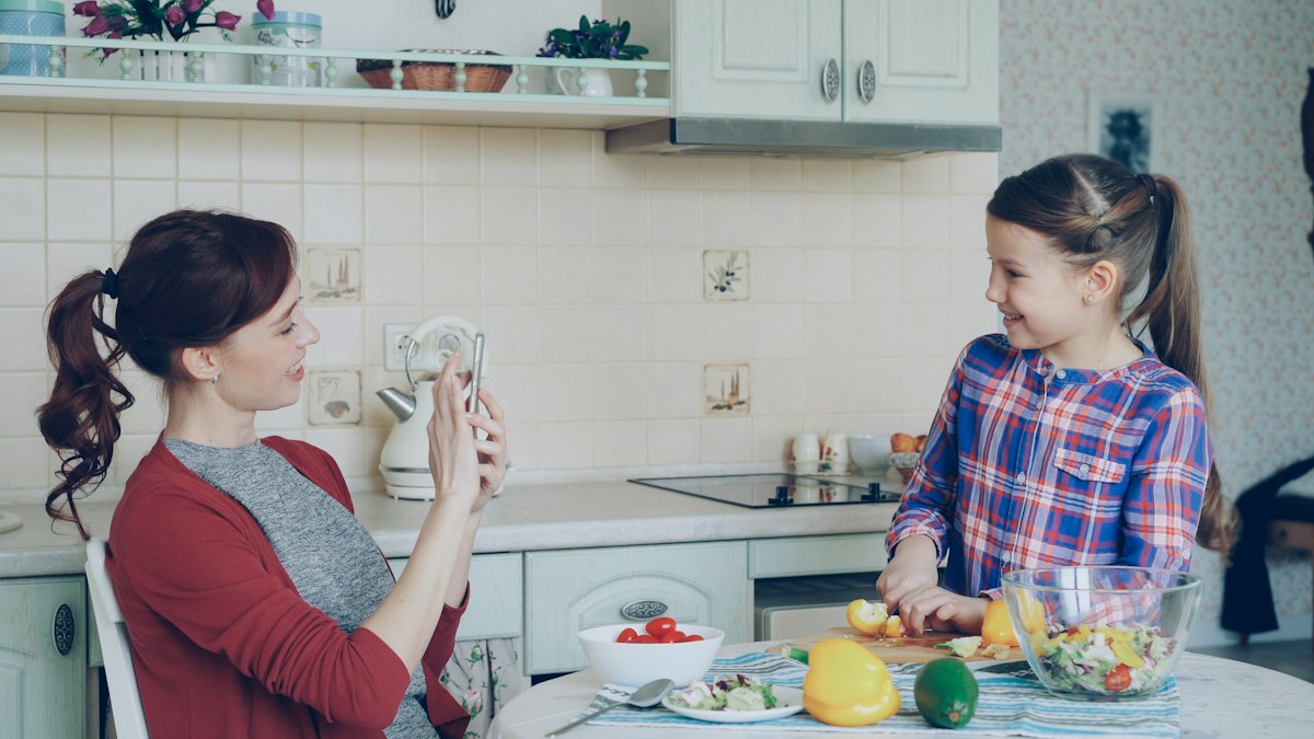 Parent and child preparing food together.